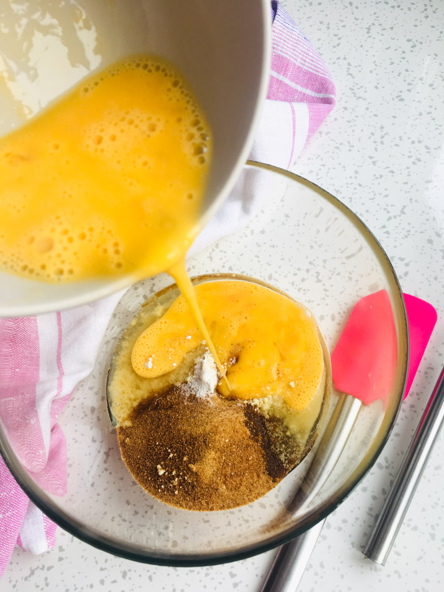 Two eggs in a small bowl and a large bowl with almond butter, coconut sugar, vanilla and butter.